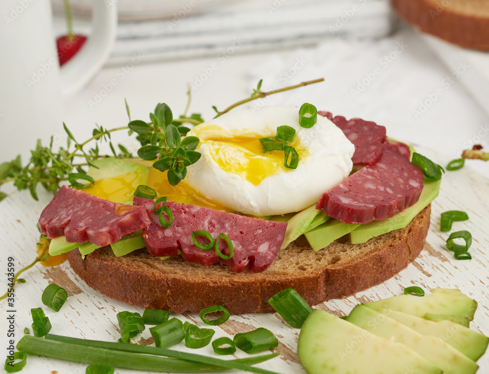 toast with poached egg and avocado on a round board, morning breakfast toast with poached egg and avocado on a round board, morning breakfast
