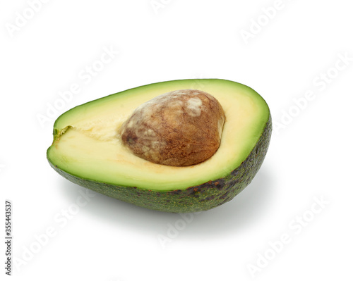 half an avocado green with brown seeds inside isolated on a white background
