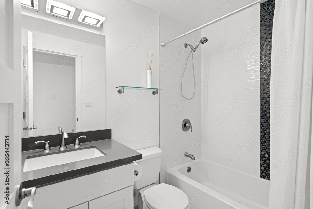 Stylish bathroom interior with dark grey countertop fitted with white porcelain sink. Stylish bathroom interior with dark grey countertop fitted with white porcelain sink.