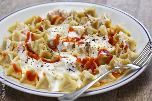 manti ( turkish ravioli type dumplings )served with garlic yoghurt, melted aleppo pepper butter and dry mint and sumac 