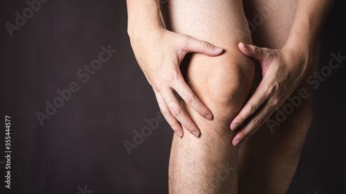 Man use hands hold on his knee.
