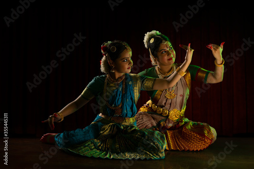 Bharatnatyam dancer teaching her young student.  
 photo