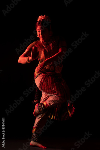 Bharatanatyam dancer doing Nataraja mudra during her performance on stage photo