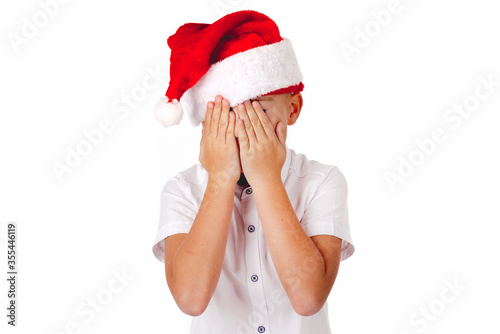 Close up Adorable boy with red hat of Christmas on a over white background