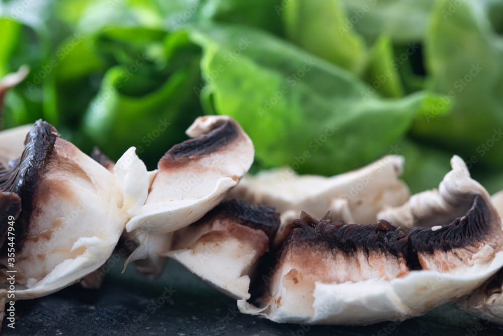 Fresh sliced mushrooms Chopped mushrooms closeup. champignons and spinach. healthy food background. Fresh sliced mushrooms Chopped mushrooms closeup. champignons and spinach. healthy food background.