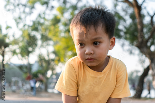 portrait of little boy crying alone in a park