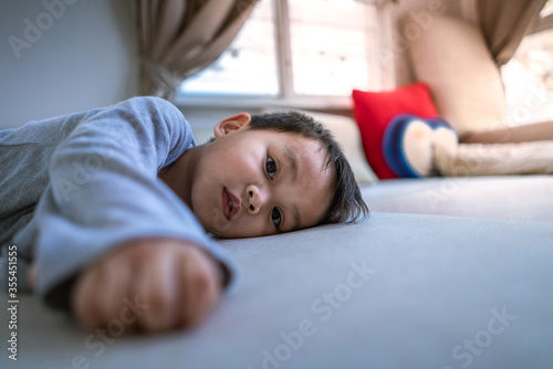 little Asian boy lying on the bed and looking at camera © pratan28