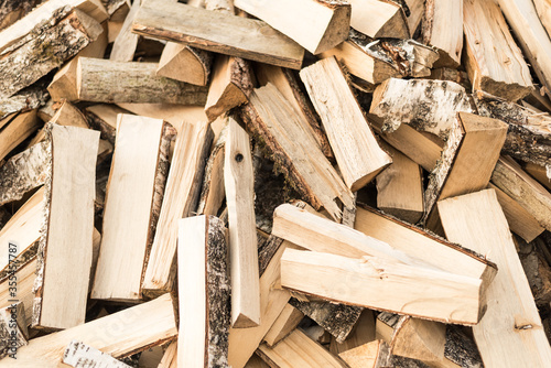 Dry split birch wood for the fireplace, stove, fire. Harvesting firewood for the winter. Texture for background.