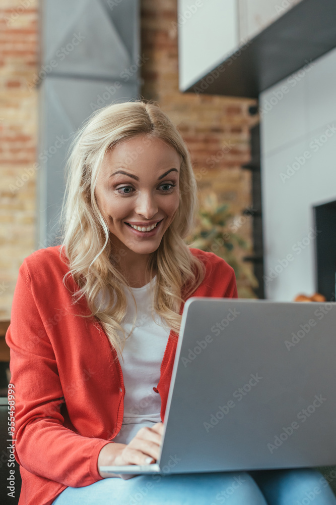 young woman smiling while using laptop at home young woman smiling while using laptop at home