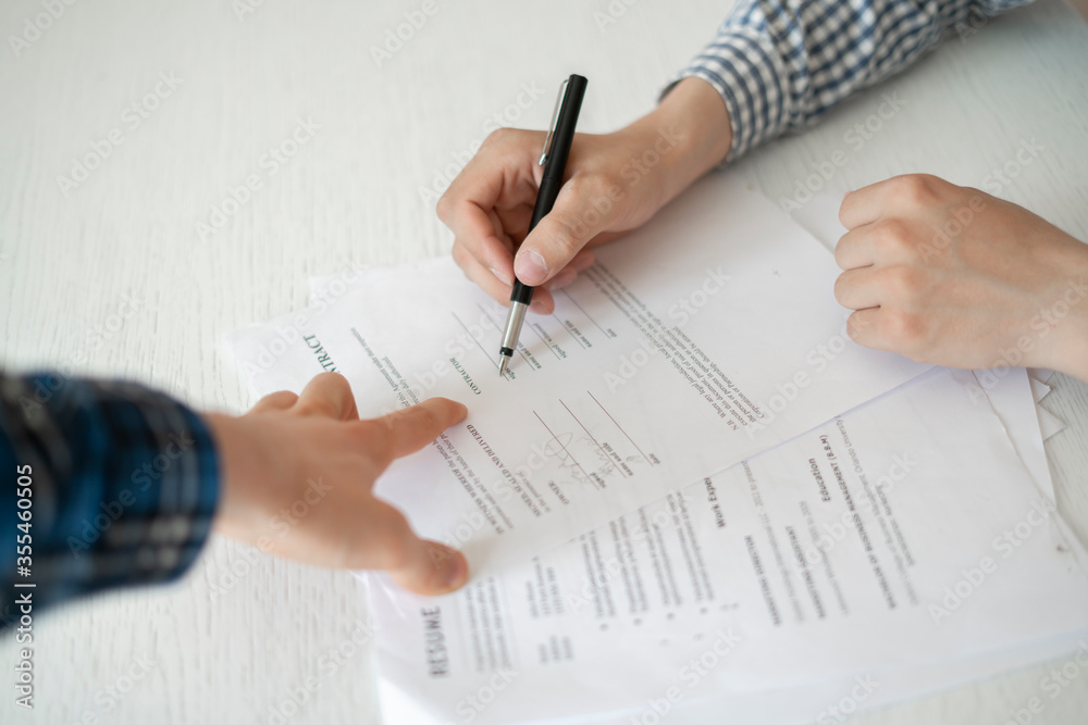 two business partners sitting at the table and sign the agreement contract document two business partners sitting at the table and sign the agreement contract document