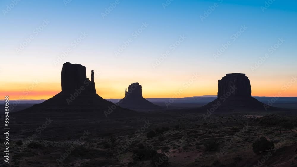Timelapse time lapse view of famous east West mittens and Merrick buttes at horizon in Monument Valley at morning sunrise colorful sunlight in Arizona, USA with orange canyon rock formations Timelapse time lapse view of famous east West mittens and Merrick buttes at horizon in Monument Valley at morning sunrise colorful sunlight in Arizona, USA with orange canyon rock formations