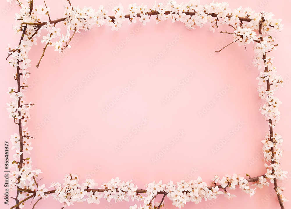 Composition of square frame spring flowers, blooming tree branches, leaves on a pastel pink background. Content for Valentines Day, Womens day. Flat lay, top view, close up, copy space for your text