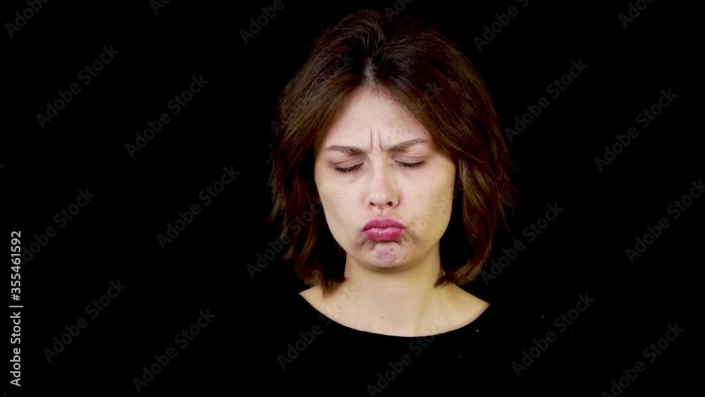 Close up of poor sad depressed young woman in black t-shirt isolated on black background Close up of poor sad depressed young woman in black t-shirt isolated on black background