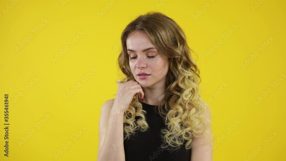 Pretty playful young woman black dress pointing up and having an idea over yellow background Pretty playful young woman black dress pointing up and having an idea over yellow background