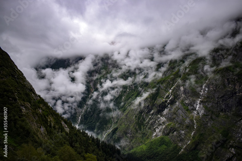 Magnificent view of clouds covered mountains and valley. A misty morning and monsoon trek to Hemkund sahib gurudwara   Valley of flowers national park in uttarakhand  India.