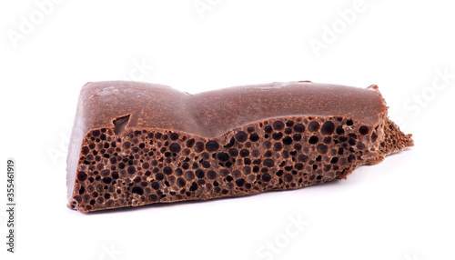 Porous chocolate bar isolated on while background. Detailed chocolate with air bubbles closeup