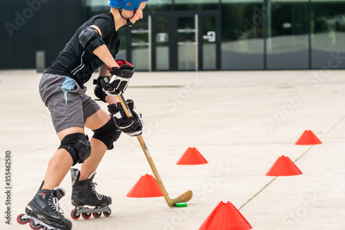 Outdoor sport, ice hockey player off ice practice on rollerskates photo