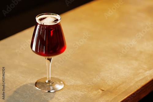 Glass with red amber ale craft beer on table photo