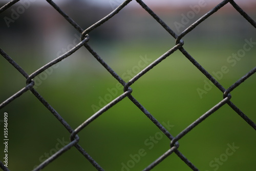 Close up of a fence against a ​green background 