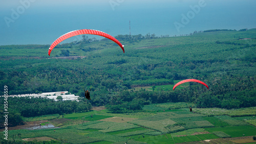 Paralayang terbang melayang di langit biru. photo