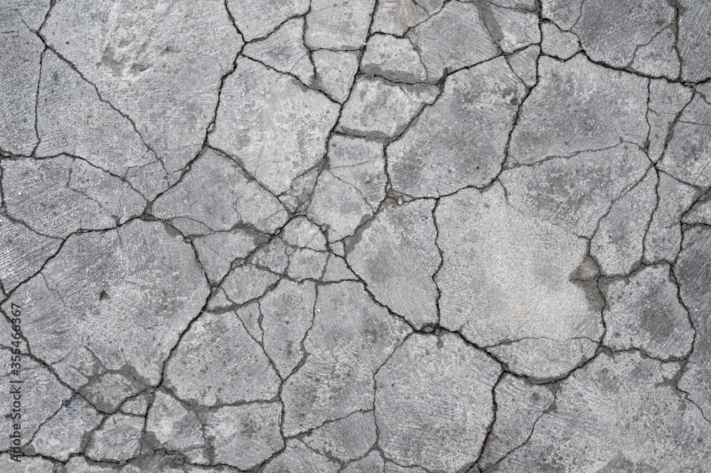 Terrain road with small rocks and cracks on the concrete wall.