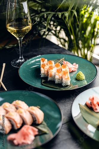 sushi rolls with rice and fish, soy sauce on a dark stone background concept of sushi restaurant summer mood 