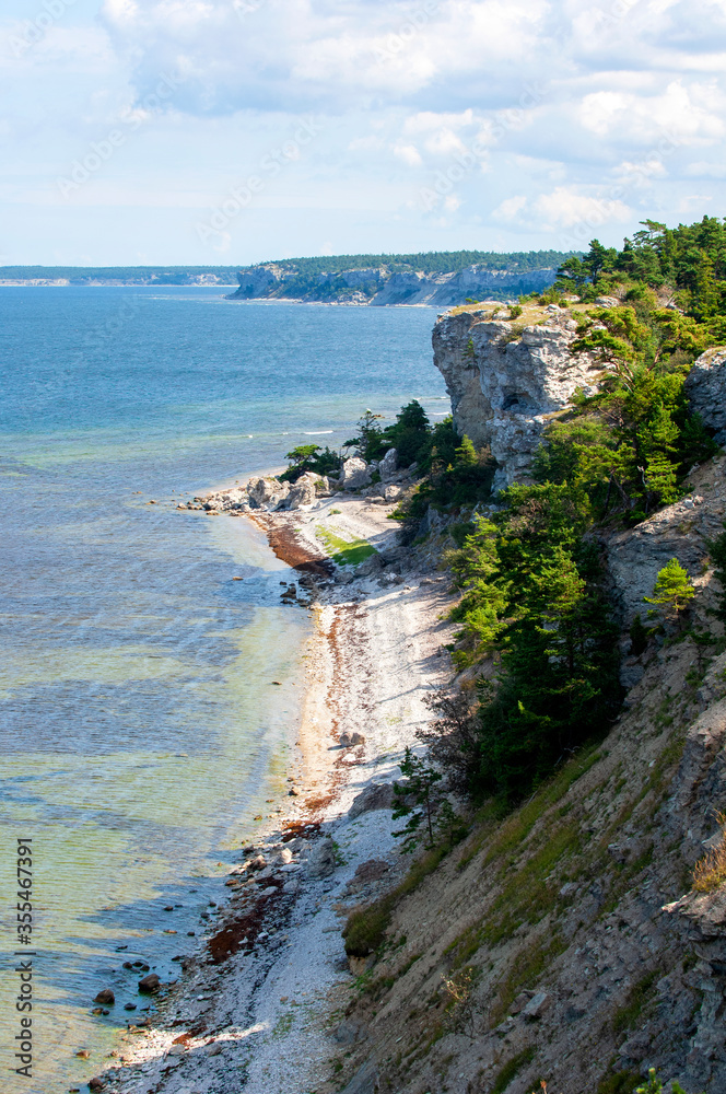 Fototapeta premium Sand beach below limestone cliff at island of Gotland, Sweden