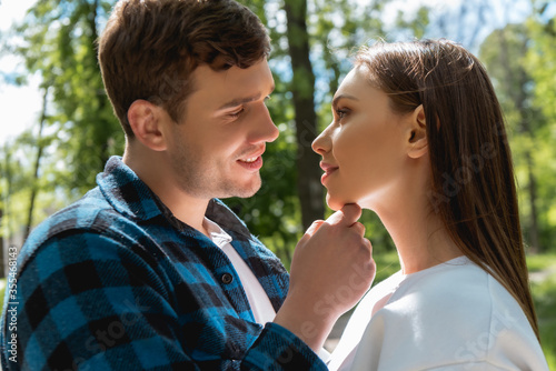 side view of happy man touching face of attractive girlfriend in park © LIGHTFIELD STUDIOS