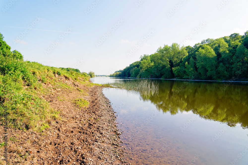 On the steep sandy banks of the River Trent looking downstream on a bright morning