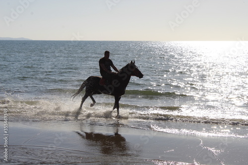 Uomo a cavallo in spiaggia 