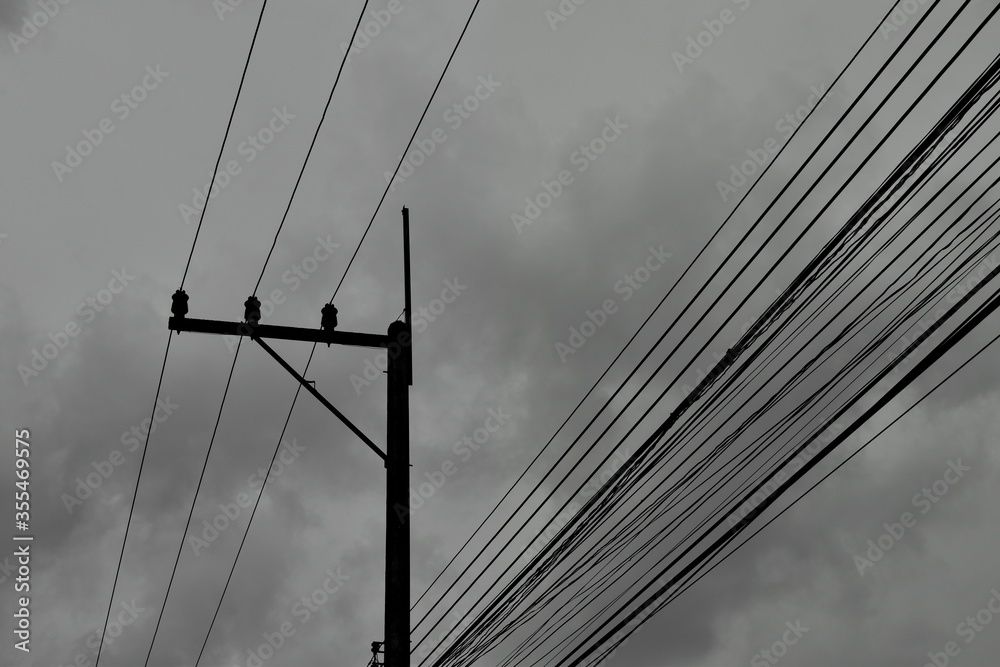 Fototapeta premium electric pole and wire on cloudy day in monochrome tone