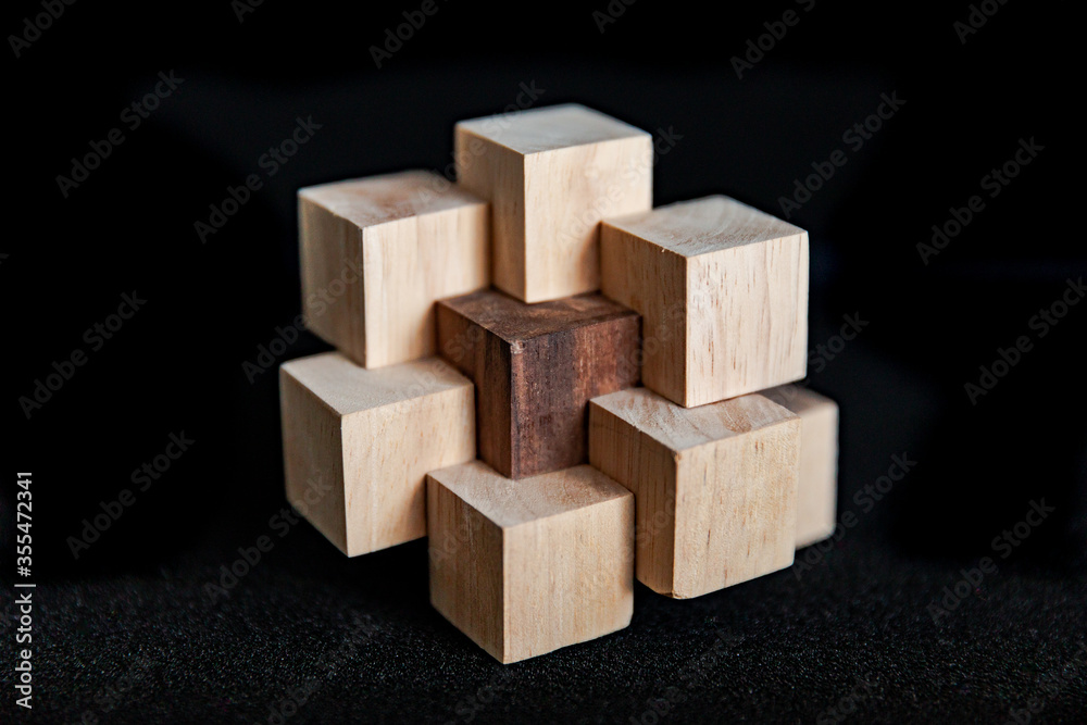 Hand made wooden puzzles on a black background, art of wood Hand made wooden puzzles on a black background, art of wood