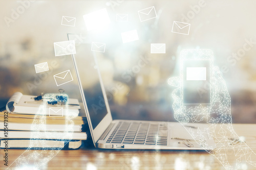 Desktop computer background in office and flying envelops hologram drawing. Multi exposure. Electronic mail concept.