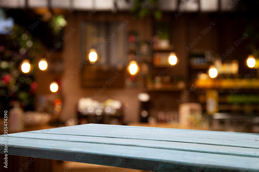 Empty wooden table top on blur light golden bokeh of cafe restaurant, bar in a dark background. Empty wooden table top on blur light golden bokeh of cafe restaurant, bar in a dark background.