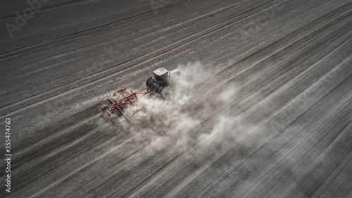 Farmers cultivating. Tractor makes vertical tillage. Aerial view