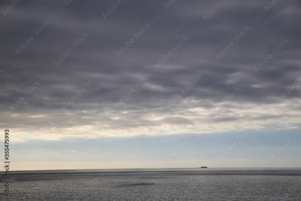Modern high speed ferry boat navigating the ocean with blue sky and clouds Modern high speed ferry boat navigating the ocean with blue sky and clouds