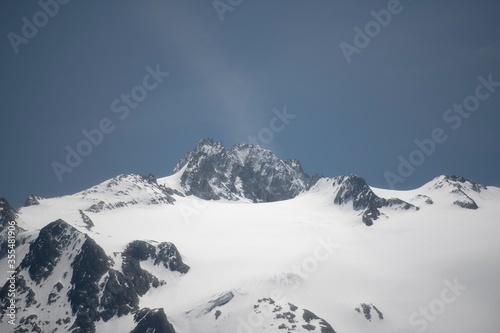Alpine mountains on a background of blue sky with clouds.