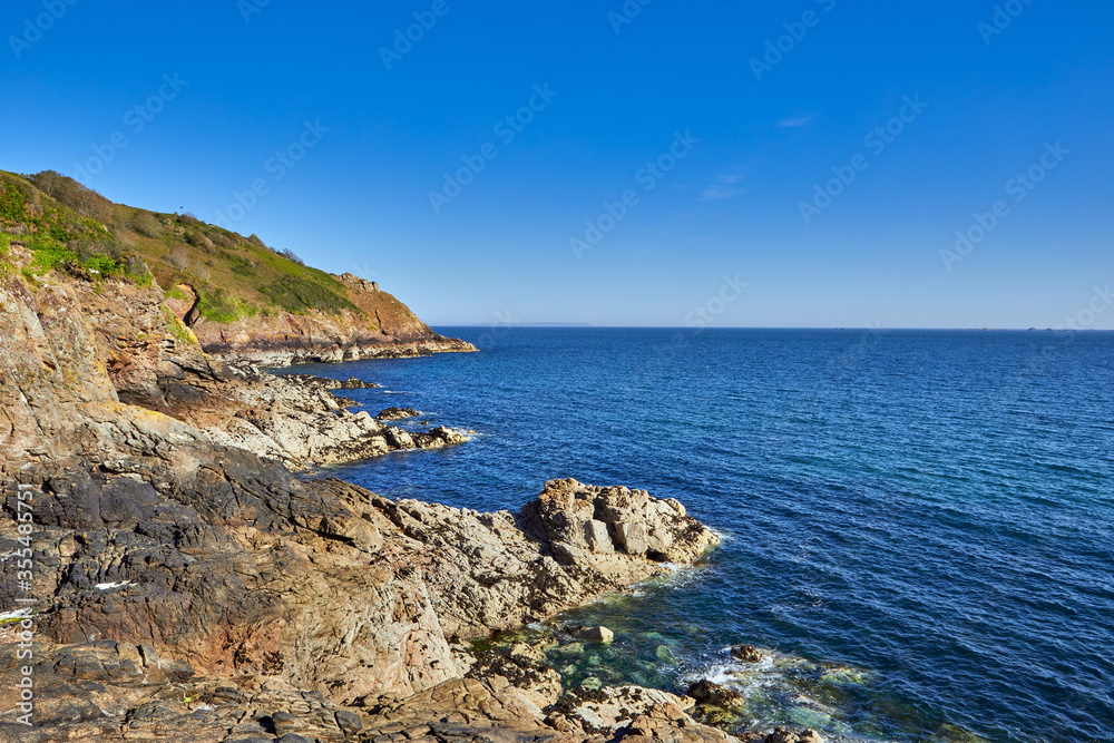 Image of the North Coast Cliffs, rocks and sea wtih clear blue sky, Jersey, Channel Islands, UK Image of the North Coast Cliffs, rocks and sea wtih clear blue sky, Jersey, Channel Islands, UK
