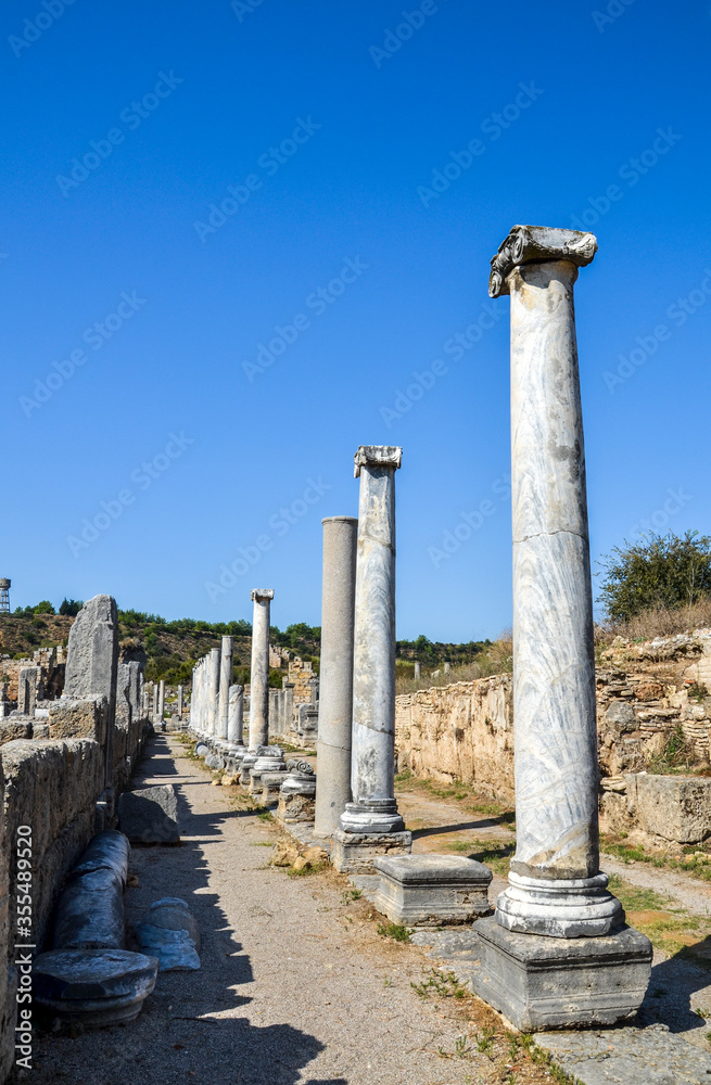Row of marble columns in the ancient roman city of Perge located near the Antalya city in Turkey.