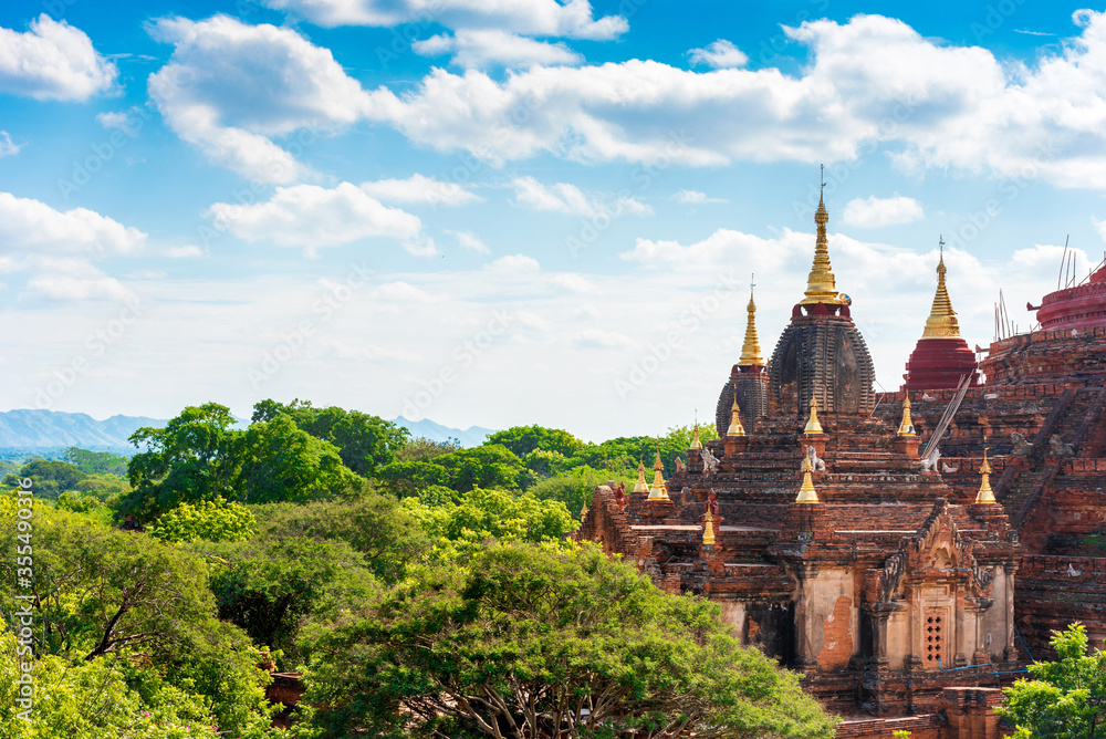 Landscape with Ancient Pagodas in Bagan, Myanmar. Trees at the Temple, Background beautiful Blue Sky with Clouds