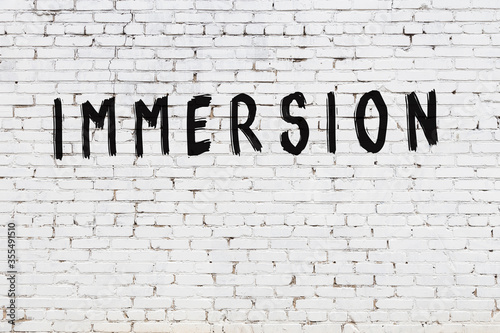 Foto Word immersion painted on white brick wall