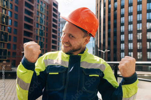 Construction man in helmet shows tongue, opened his mouth with joy