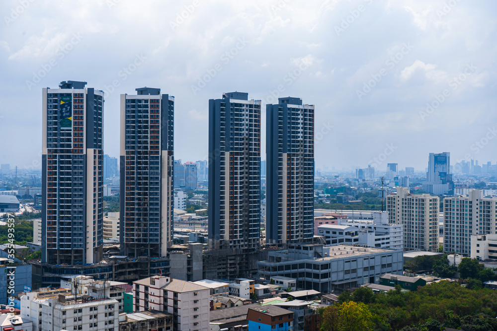 View from the high floor of the streets of Bangkok. Tall buildings and roofs of small houses. City landscape