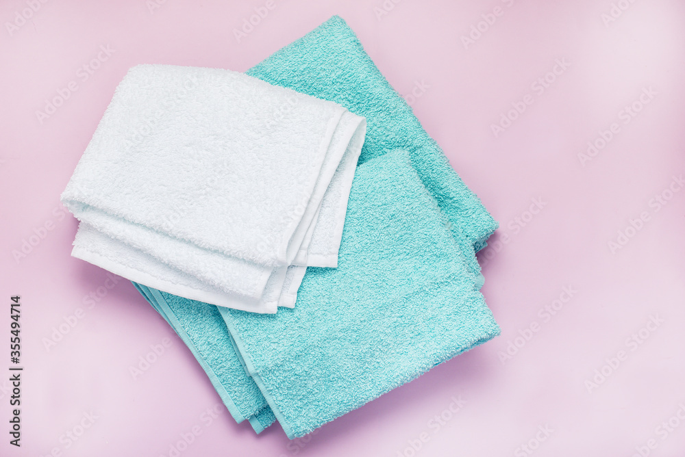 Pile of Towels Light Green and White Towels on Pink Background Top View Horizontal Pile of Towels Light Green and White Towels on Pink Background Top View Horizontal