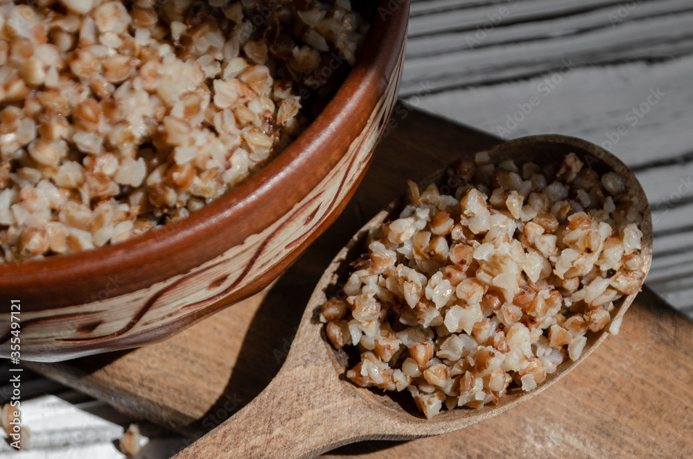 buckwheat porridge in a clay plate with butter and a wooden spoon buckwheat porridge in a clay plate with butter and a wooden spoon