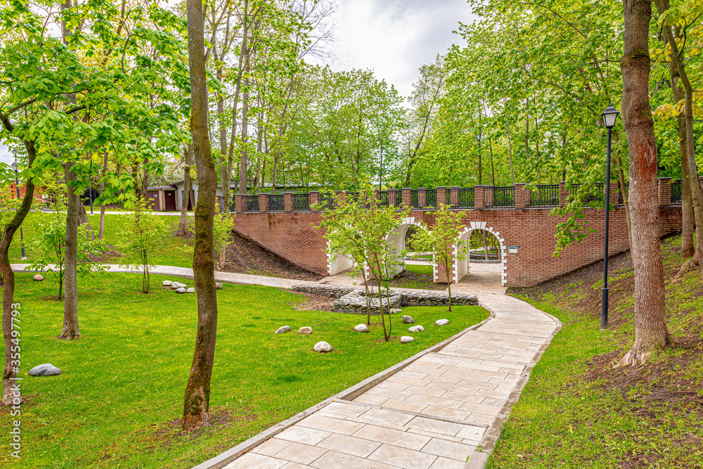 The ancient brick bridge pedestrian in the spring park and the peat bog The ancient brick bridge pedestrian in the spring park and the peat bog