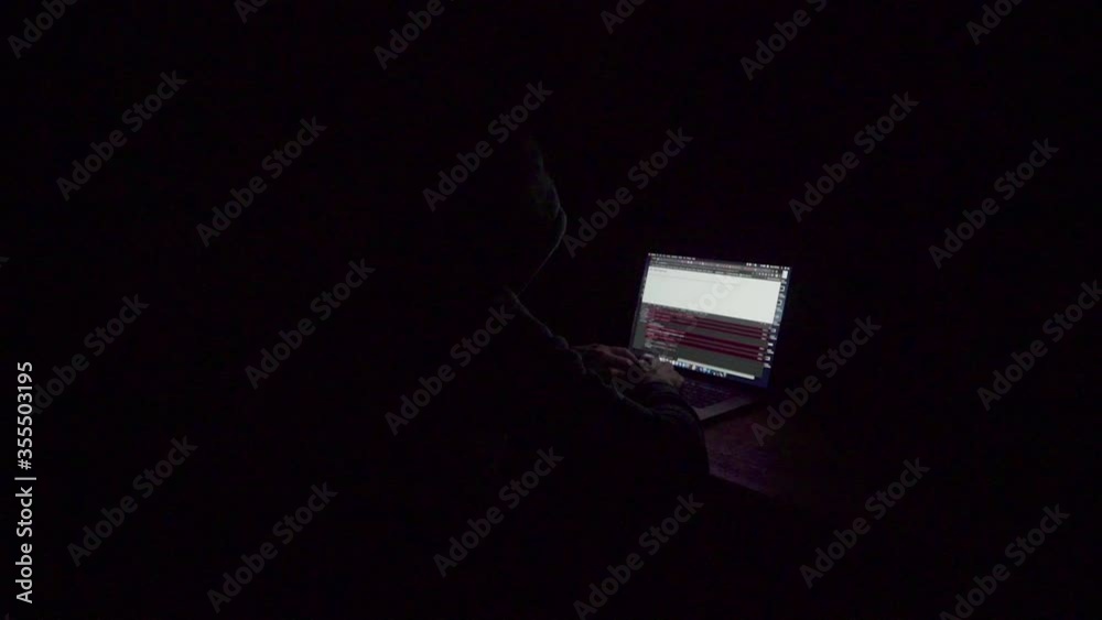 Hacker concept using a computer with stong lighting and dramatic impression