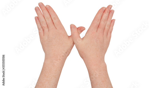Freckled white hands,  thumbs crossing, fingers pressed together, palms down.  Female hand isolated.  Hand casting a spell gesture