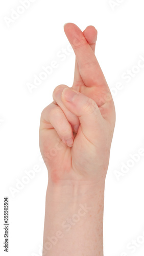 Freckled white hand. Hand making the fingers crossed gesture, view from front. Female hand isolated