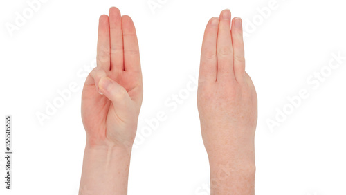 Freckled white hands. Isolated woman's hand, front and back, index second and ring fingers together, thumb and little finger tucked in. Gesture indicating the number three